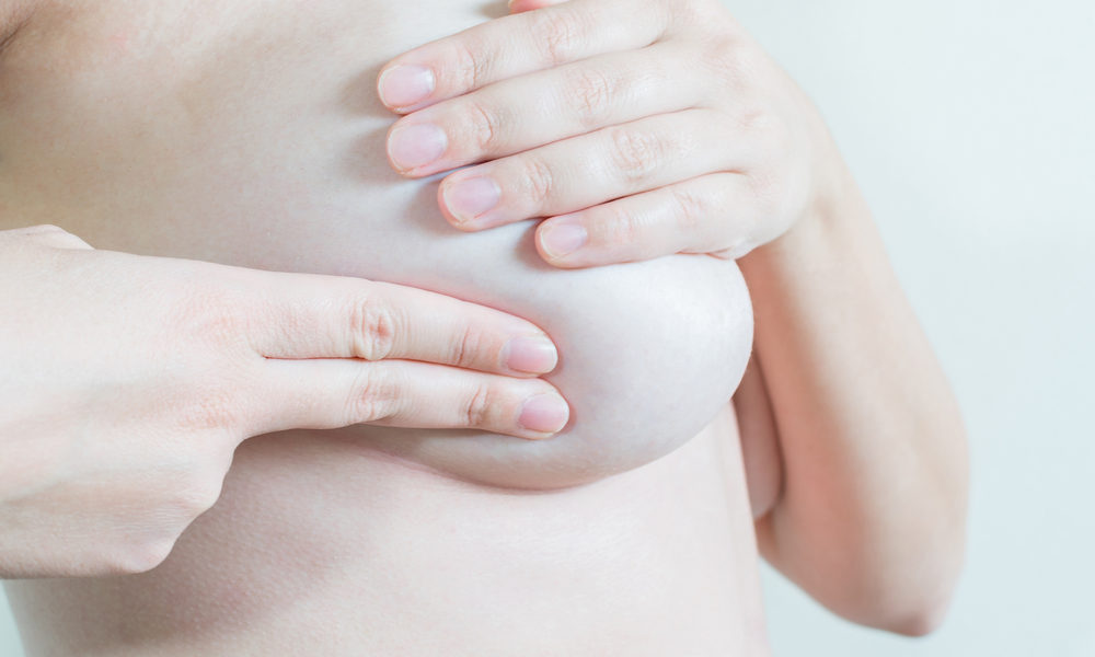Mulher utiliza as mãos para realizar o autoexame das mamas